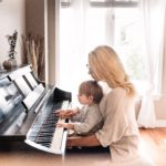 Woman playing piano with her chind in her lap