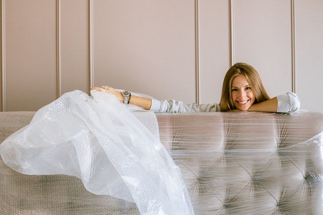 a woman unpacking her mattress and smiling
